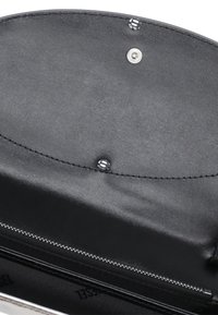 Interno di un portafoglio in pelle nera con una texture liscia, comparto zip e dettagli metallici lucidi. Chiusura a pressione visibile.