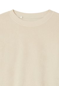 T-shirt beige à manches courtes et col rond avec des coutures visibles autour du col.