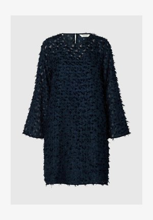 Granatowa sukienka z teksturowanym wzorem przypominającym pióra, o rękawach do trzech ćwiartek i okrągłej dekolcie; ma otwarcie w kształcie łezki z tyłu.