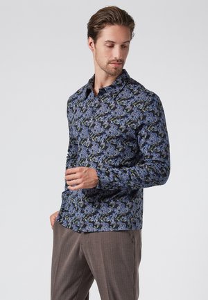 Chemise à manches longues marine avec un motif floral comprenant des accents bleus et verts. Col boutonné et design ajusté.