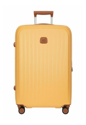 Gelber Hartschalen-Koffer mit braunem Griff und Besatz, vier schwarzen und braunen Spinner-Rollen und einer kleinen rechteckigen Logoplakette.