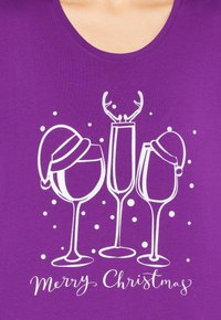 Maglietta viola con tre bicchieri di vino e la scritta "Buon Natale". I bicchieri sono decorati con cappelli di Babbo Natale e corna di renna decorative.
