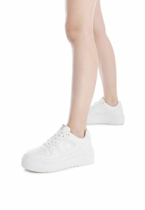 Sneakers bianchi con una texture in pelle liscia, punta perforata, suola spessa e lacci rotondi. Design minimalista con dettagli del logo discreti.