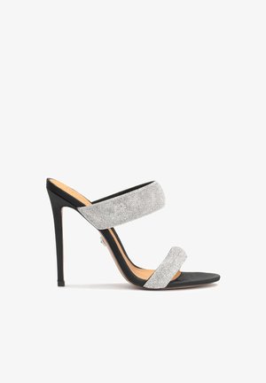 Hoge hak sandaal met een zwarte zool, straps met zilveren rhinestones en een open teen ontwerp. Beschikt over een stiletto hak en een textuur bovenkant.