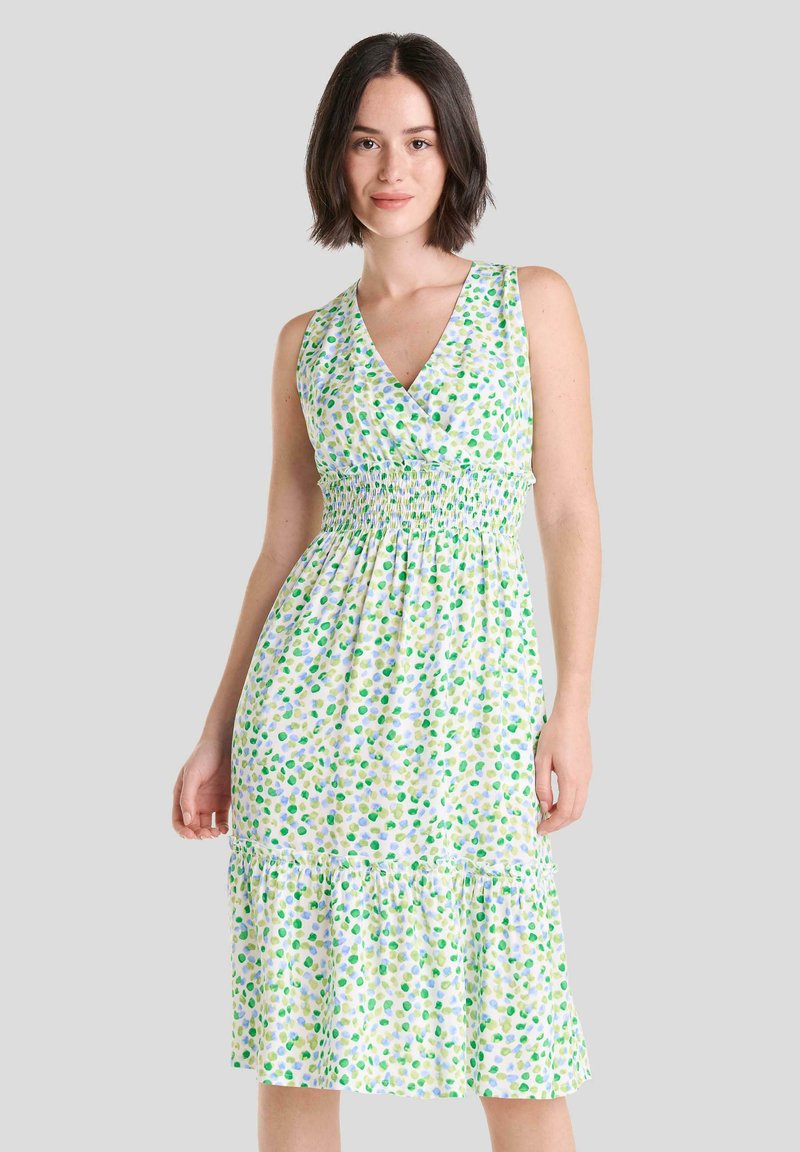 Vestido sin mangas de lunares verdes y azules con escote en V, corsé fruncido y dobladillo con volantes. Hecho de una tela ligera con un estampado floral.