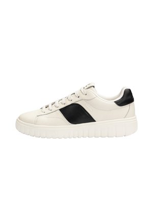 Low-top white sneaker with thick sole, black side panel and heel, and white laces on plain white background.