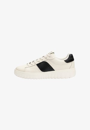 Witte lage sneaker met dikke zool, zwart zijpaneel en hiel, en witte veters op een effen witte achtergrond.