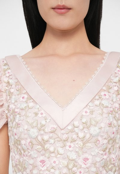 Ružové vyšívané šaty s výstrihom do V lemovaným čipkou, zdobené kvetinovými vzormi a flitrami na priesvitnej látke.