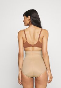 Brązowy biustonosz i cieliste, wysokie body modelujące, bezszwowy design, gładka tekstura, regulowane ramiączka oraz prosty zapięcie z tyłu.