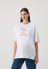 White oversized t-shirt made of cotton, featuring a cartoon deer and butterflies graphic with "Drama Mama" text below in purple.