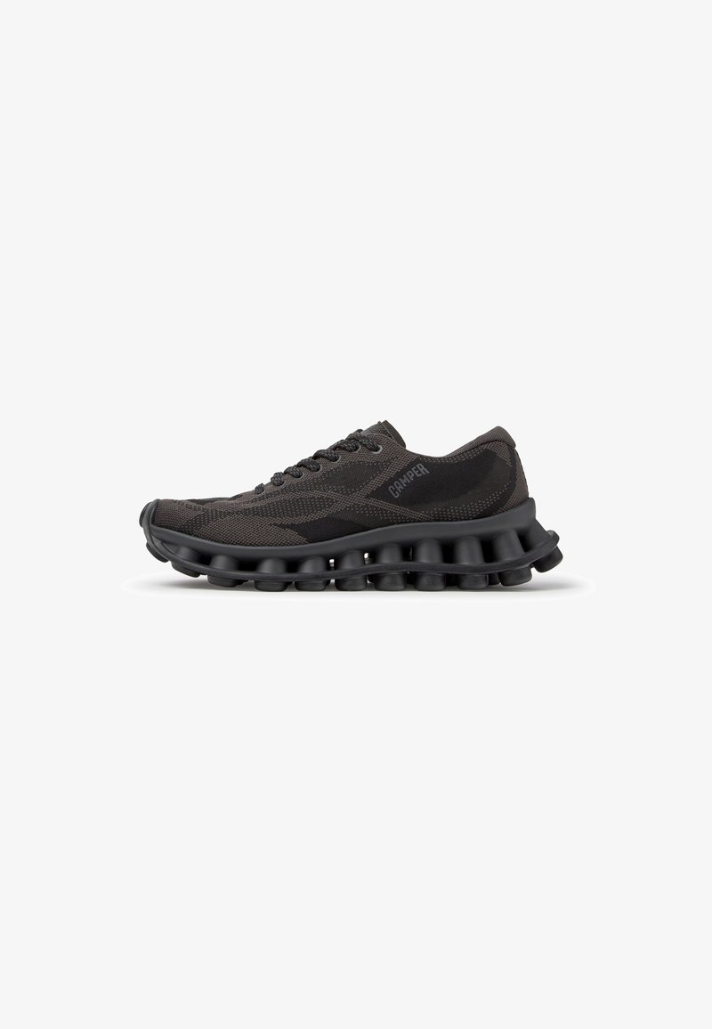 Chaussure de sport noire à lacets avec empeigne en mesh respirant et semelle segmentée unique conçue pour l'amorti et la flexibilité, marquée du logo Camper.