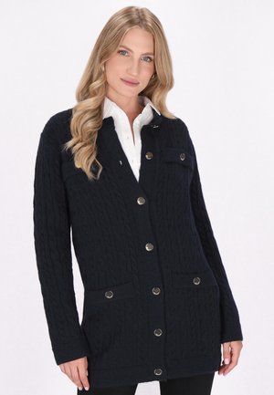 Marineblaue Zopfmuster-Strickjacke mit Knopfverschluss, zwei Fronttaschen und Beschlägen in Silberoptik. Weicher Stoff, lange Ärmel.