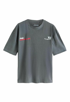 Szürke pamut póló rövid ujjakkal, kerek nyakkal, piros és fehér nyomott szöveggel: "Jeep WRANGLER" és "YJ Az eredeti 4x4."