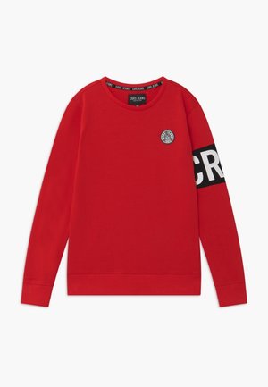 Rotes Sweatshirt mit langen Ärmeln. Verfügt über einen Rundhalsausschnitt, schwarzen Schriftzug auf dem Ärmel und ein rundes Logo auf der Brust. Aus Baumwollmaterial.