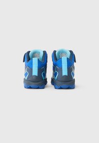 Baskets de sport bleu et marine avec une surface texturée, un talon renforcé et des accents bleu clair. Elles sont dotées d'une sangle Velcro pour un ajustement sécurisé.