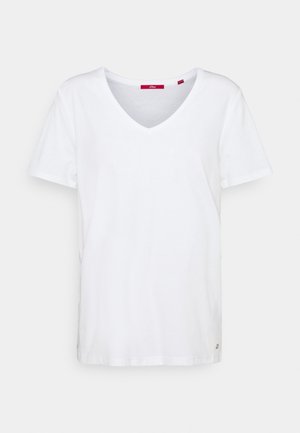 Hvid kortærmet V-hals bomuld T-shirt med en lille metal logo-tag nær den nederste kant på højre side.