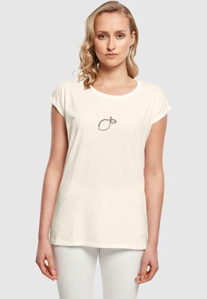 Cremefarbiges T-Shirt aus weichem Stoff, mit einer einfachen schwarzen Linienzeichnung einer Zitrone mit einem Blatt, rundem Ausschnitt und aufgerollten Ärmeln.