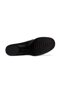 Semelle de chaussure noire avec un fond en caoutchouc texturé, présentant des rainures pour une meilleure adhérence. Le design est plat avec une forme arrondie et un minimum de détails.