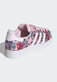 Roosade lillemustriga tossud valgete triipude ja detailidega, silmapaistev sile pind ja ümar kuju. Tugevdatud konts ning pehme sisemus.