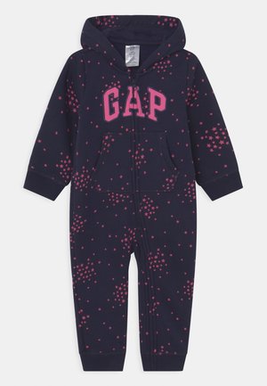 Body bébé bleu marine avec capuche, fermeture éclair à l'avant, motifs d’étoiles roses et logo "GAP" rose sur la poitrine.