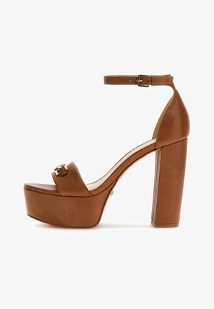 Sandal a piattaforma con tacco alto in pelle marrone, con cinturino alla caviglia, punta quadrata e dettagli in hardware dorato. Design robusto con tacco a blocco.
