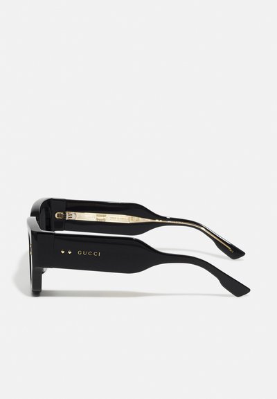 Black rectangular sunglasses with glossy finish. Features gold hardware and brand logo on the temples. Clean design with straight arms.