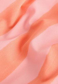 Tissu doux avec des plis lisses dans des rayures larges alternées orange corail et rose clair.