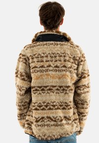 Pullover in peluche, patterned in beige, marrone e ruggine, con una superficie textured e un colletto alto. Fodera nera visibile.
