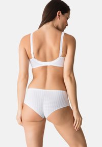 Conjunto de lencería blanca que incluye un sujetador suave con tirantes ajustables y una braga texturizada con un patrón de cuadrícula.