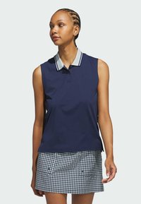 Navy sleeveless polo shirt with a light striped collar, paired with a checkered skirt featuring blue and white patterns and side pockets.