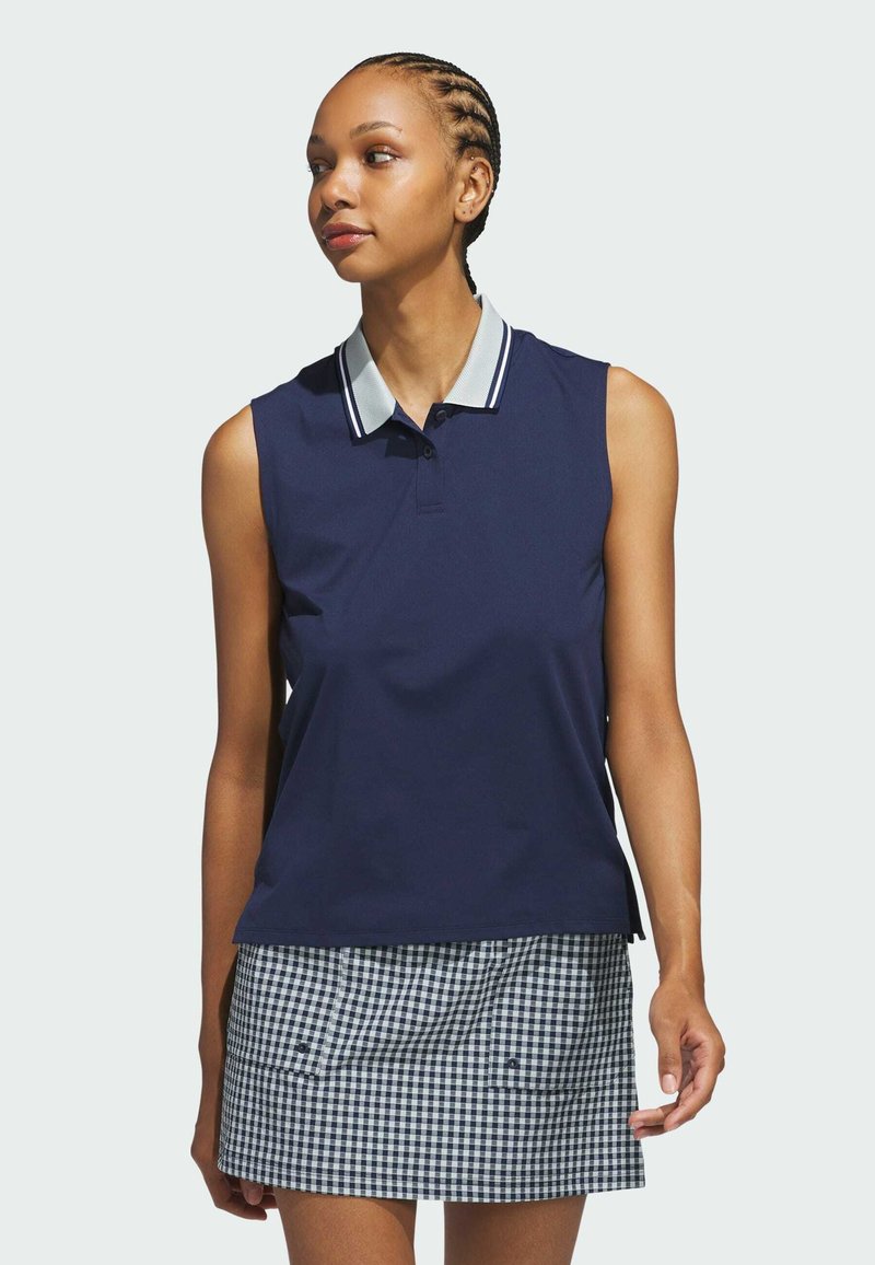 Navy sleeveless polo shirt with a light striped collar, paired with a checkered skirt featuring blue and white patterns and side pockets.