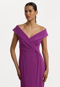 Vestido roxo off-the-shoulder com decote em V profundo, detalhe torcido reunido na cintura e textura lisa e ajustada.