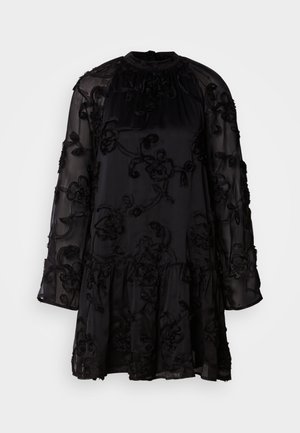 Vestido preto feito de tecido transparente, com bordados florais e uma bainha larga. Mangas longas com detalhes franzidos e um colarinho alto.