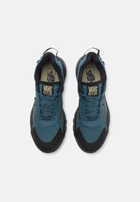 Adidași blue Vans cu o suprafață texturat�ă, accente negre și talpă groasă. Prevăzuți cu șireturi, guler căptușit și logo pe limbă.
