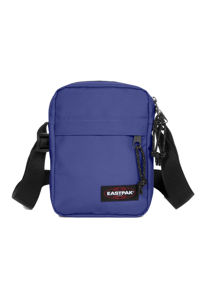 Lila tygaxelväska med en blixtlåsförsedd huvudfack och frontfack, med svart axelrem och Eastpak-logotyp.
