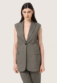 Šedý bezrukávový blazer s hlubokým výstřihem do V, jednoduchým zapínáním na jeden knoflík a dvěma předními kapsami. Texturovaná látka s jemným vzorem.