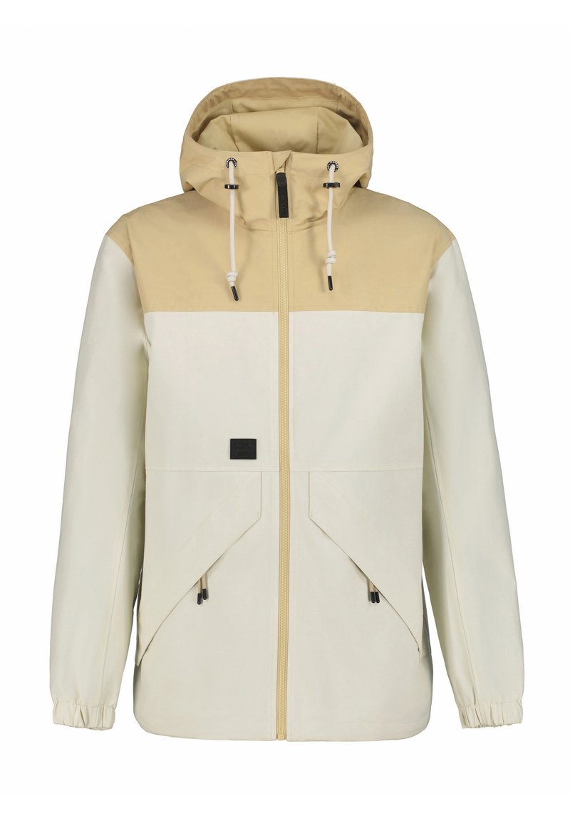 Letvægtsjakke i beige og creme med hætte, frontlynlås, to store skrå lommer og elastiske manchetter. Har justerbare snore.