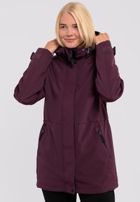 Lilla softshell jakke med hætte, frontlynlås og to sidelommer. Har velcro detaljer på ærmerne for justerbar pasform.