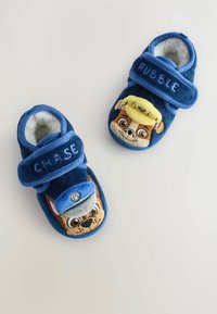 Blaue Plüschslippers mit Chase und Rubble aus "Paw Patrol". Weiches, flauschiges Material mit Klettverschlussriemen. Bestickte Charaktere auf den Zehen.