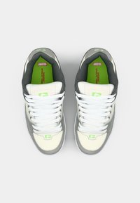 White and gray sneakers with green accents, featuring a textured leather upper, flat white laces, and a padded collar. Notable brand logo present.