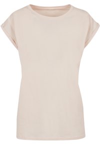 Light pink T-shirt in soft cotton fabric, featuring a round neck, short rolled sleeves, and a relaxed fit. Smooth texture, minimal details.