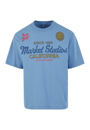 Tricou din bumbac de culoare albastru deschis, cu mâneci scurte. Prezentă un text îndrăzneț în nuanțe de navy și roșu; grafica include „Market Studios” și un logo circular.