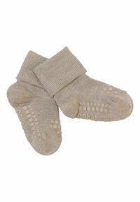 Chaussettes pour bébé beige clair avec des bordures repliées et des grips en caoutchouc antidérapants sur les semelles formant le mot "babyGO" et de petites formes.