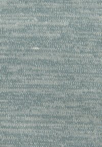 Texturiertes Strickgewebe in einem sanften Blauton, mit einem subtilen Muster und Variationen im Farbton, das eine gleichmäßige Webart und Weichheit zeigt.