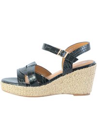 Zwarte faux lederen wedge sandalen met een geweven stro-platform, voorzien van gekruiste banden en een enkelband met een metalen gesp.