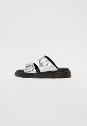 Silver leather slide sandal with two adjustable buckle straps and a thick black sole against a plain white background.