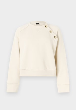 Kremasta majica s okroglim izrezom, raglanskimi rokavi in tremi zlatimi gumbi na levem ramenu. Tkanina iz bombažnega materiala, krajši kroj.