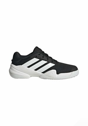 Chaussure de sport basse noire et blanche avec une tige en mesh, une semelle blanche et trois bandes blanches sur le côté.