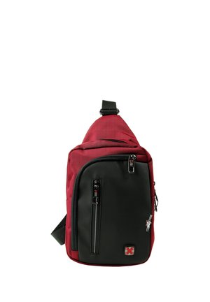 Kompakter roter und schwarzer Sling-Rucksack mit mehreren Reißverschlussfächern und verstellbarem Schulterriemen, die Vorderseite verfügt über eine kleine Logo-Plakette.