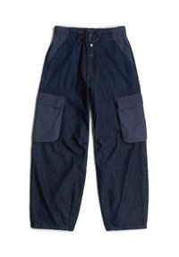 Sukne baggy denim tummansinisin värvi, millel on nöörivöö, kaks suurt küljetaskut ja kontrastsetest kangast paneelid ülemistes osades.